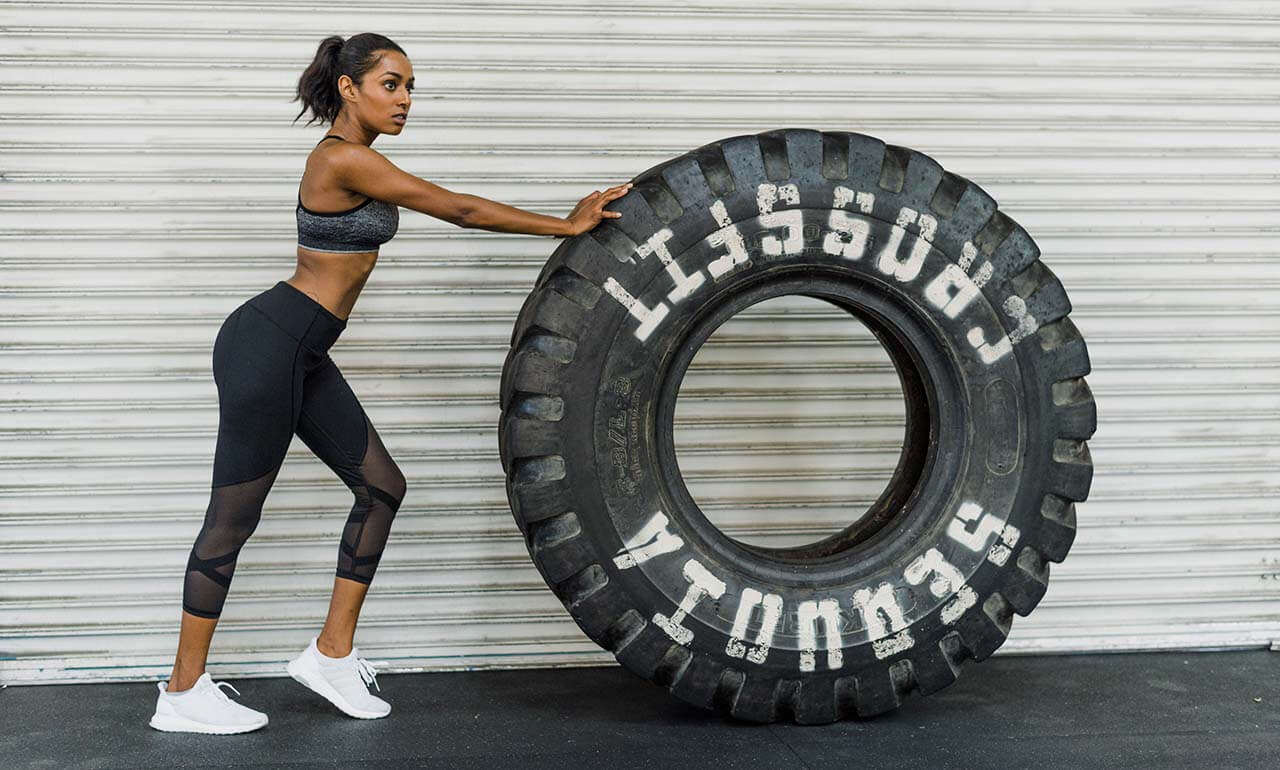 Gym owners Athlete pushing a large tire in a gym
