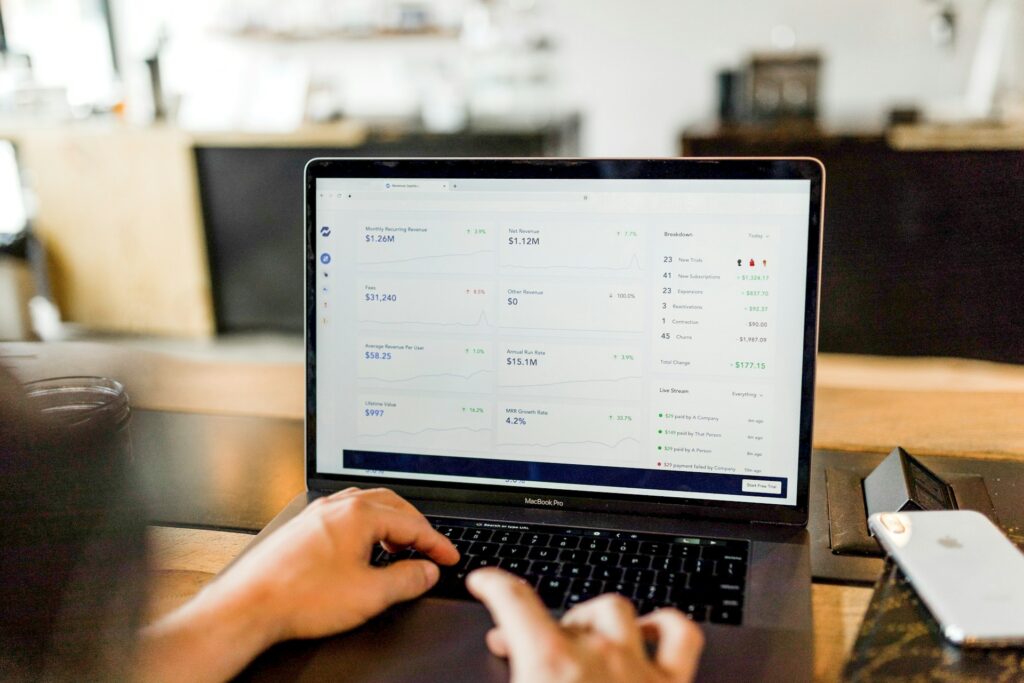 Hands typing on a laptop showing a business dashboard