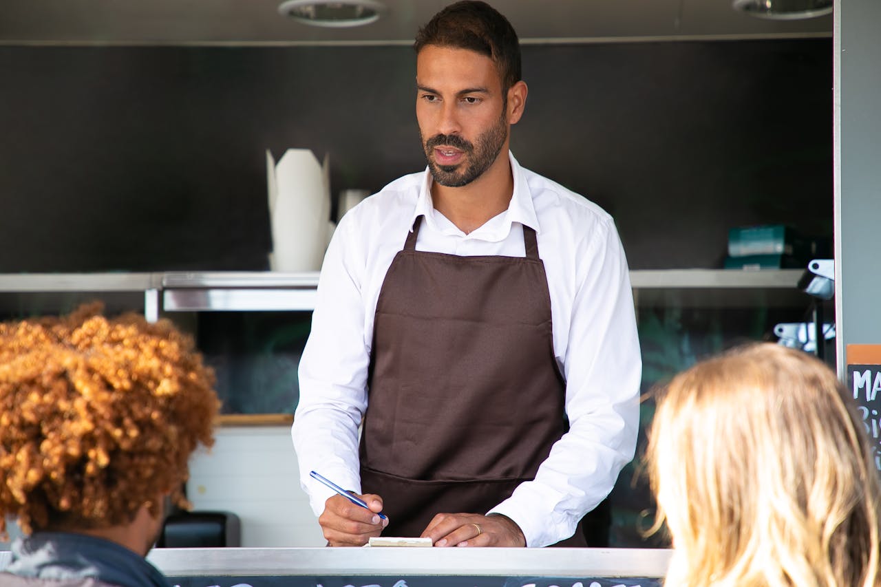 Restaurant owner in an apron serving customers