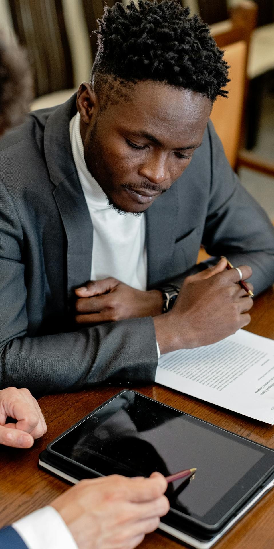 Owner-Manager Tax Planning Meeting Business owner reviewing documents and a tablet with an advisor